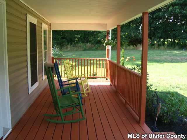 65 Peak Road, Unit HOME WARRANTY IN PLACE Stone Ridge, NY 12484 - Photo 1 of 6 a view of balcony with furniture and garden
