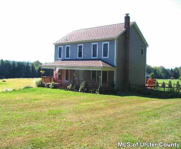 65 Peak Road, Unit HOME WARRANTY IN PLACE Stone Ridge, NY 12484 - Photo 5 of 6 a front view of a house with garden