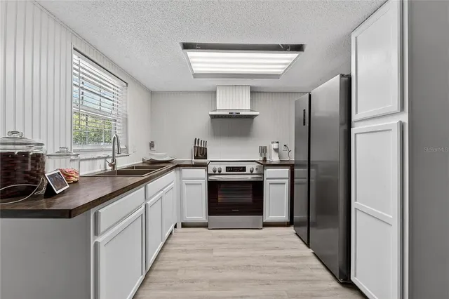 a kitchen with stainless steel appliances granite countertop a refrigerator and a stove top oven