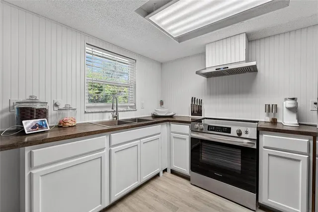 a kitchen with a sink a stove and cabinets
