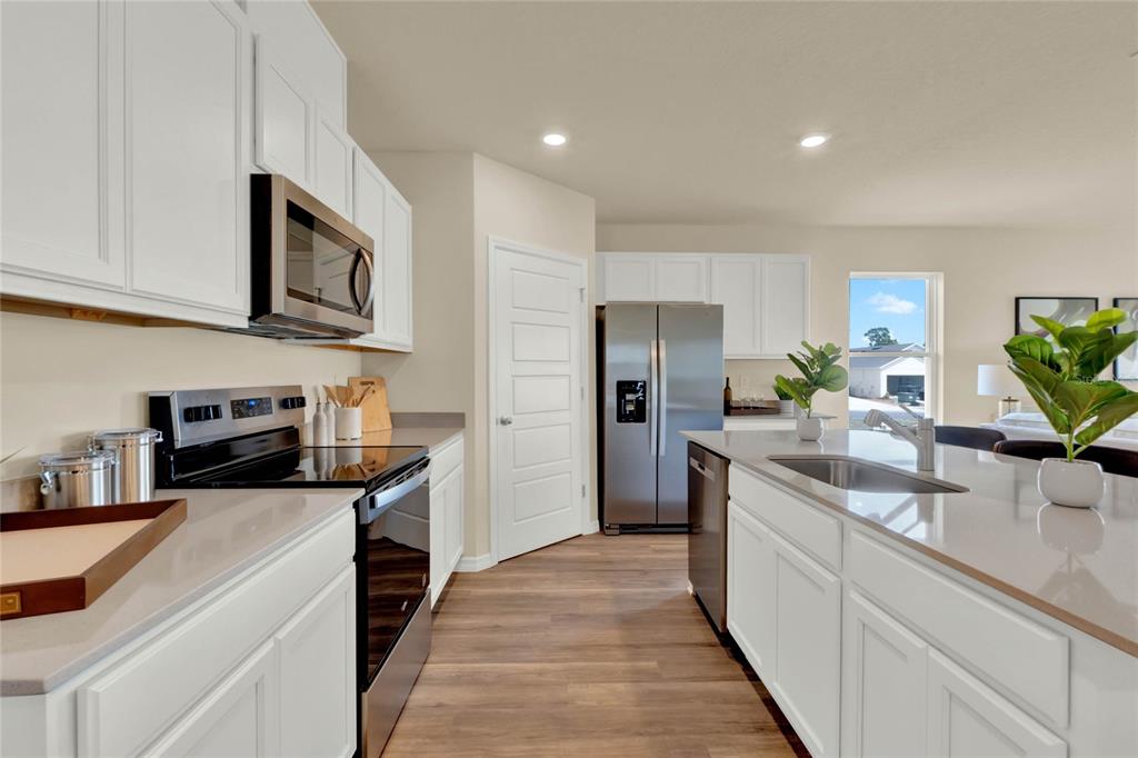 3517 Nettle Loop Tavares, FL 32778 - Photo 12 of 27 a kitchen with stainless steel appliances granite countertop a sink and a refrigerator