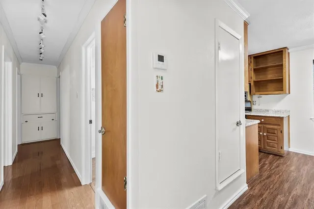 a view of a hallway with wooden floor and closet area