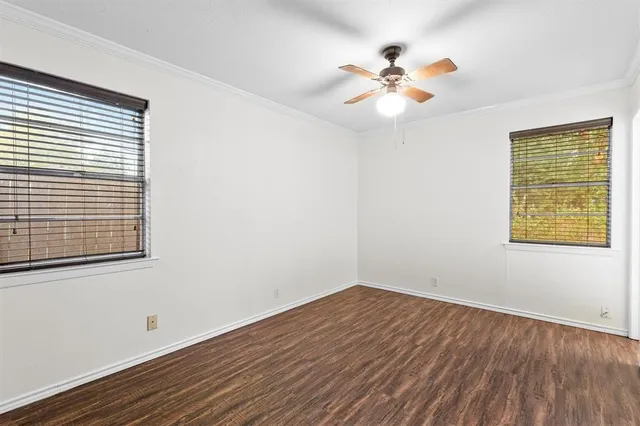a view of a room with wooden floor and a ceiling fan