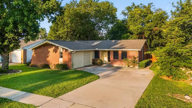 a view of a house with a big yard and large tree