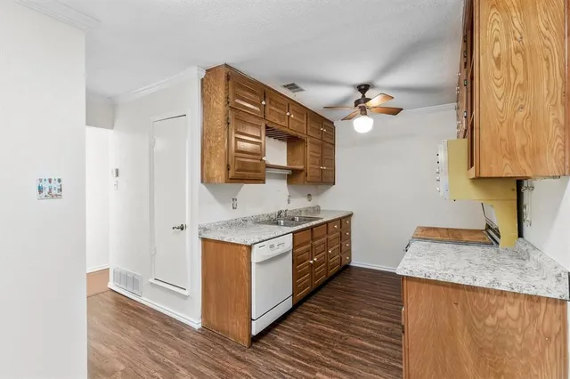 a kitchen with stainless steel appliances granite countertop a sink and a stove with wooden floor