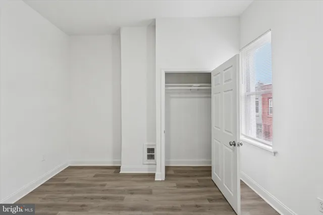 a view of empty room with wooden floor
