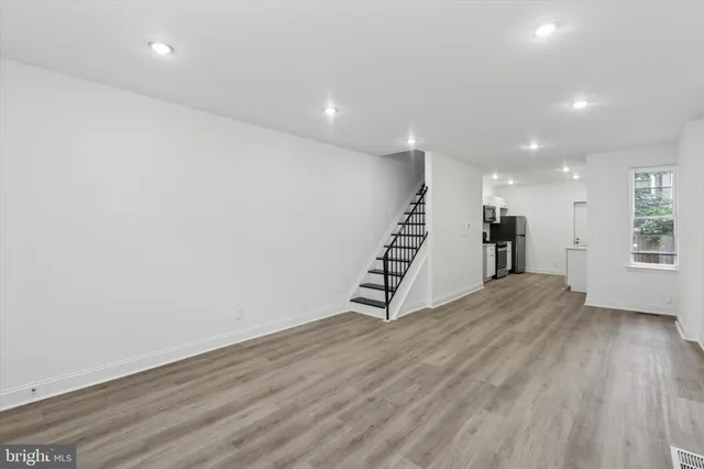 an empty room with wooden floor and stairs