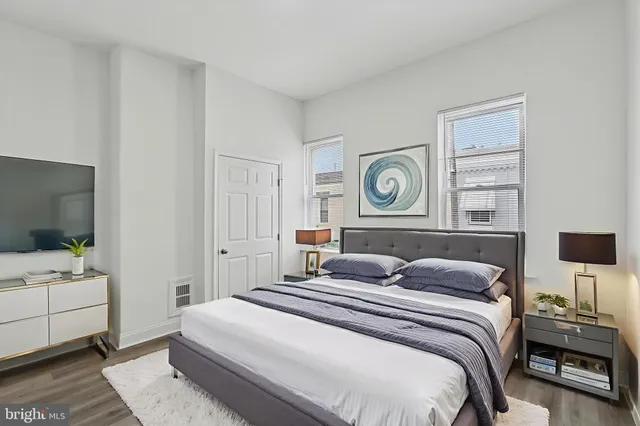 a bedroom with a bed and a lamp on dresser