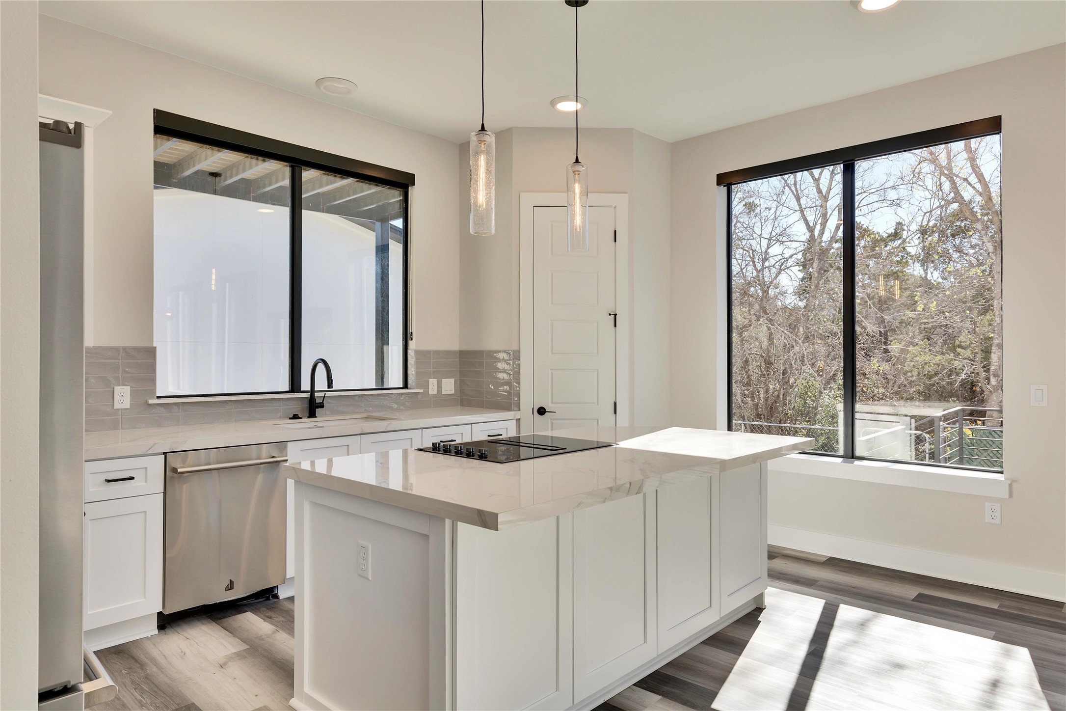 1304 Minnie Drive Austin, TX 78732 - Photo 13 of 28 Kitchen featuring white cabinetry, decorative light fixtures, light stone counters, and backsplash