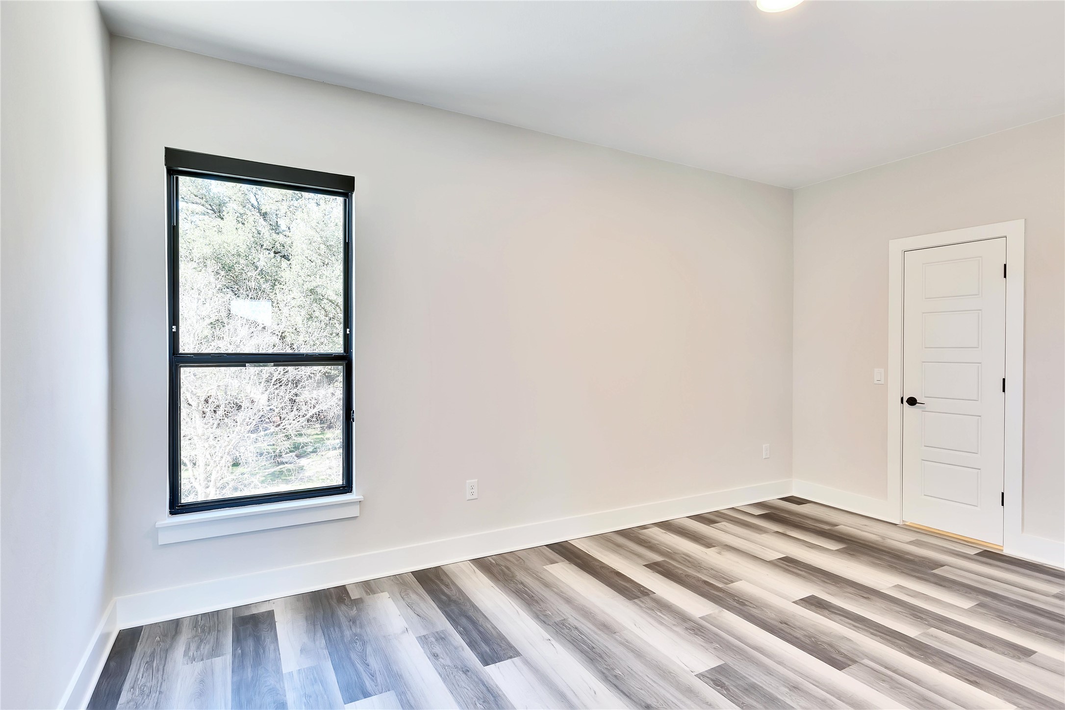 1304 Minnie Drive Austin, TX 78732 - Photo 23 of 28 Unfurnished room with light wood-style floors and baseboards
