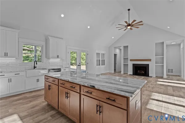 a kitchen with granite countertop white cabinets and sink