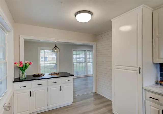 a kitchen with white cabinets and sink