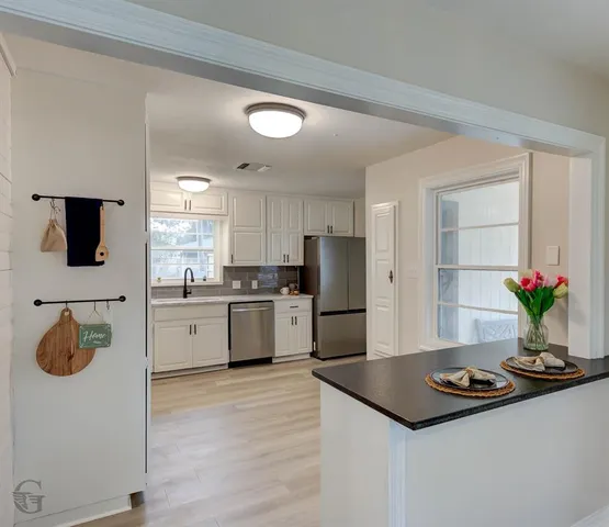 a kitchen with a refrigerator and a stove top oven