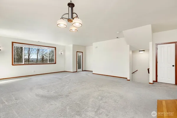 a view of an empty room with a fireplace and a window