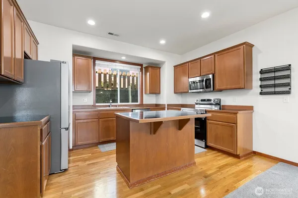 a kitchen with stainless steel appliances granite countertop a stove a sink and a microwave