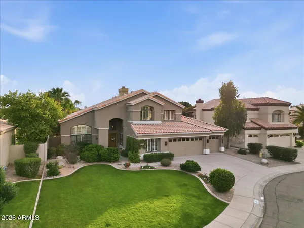 a view of a house with a yard and potted plants