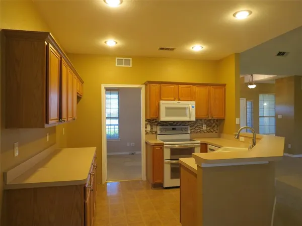 a kitchen with kitchen island a sink appliances and cabinets