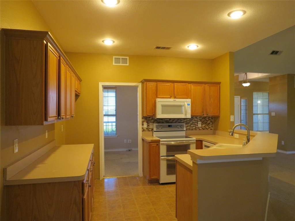 109 Country View Lane Fate, TX 75189 - Photo 3 of 24 a kitchen with kitchen island a sink appliances and cabinets