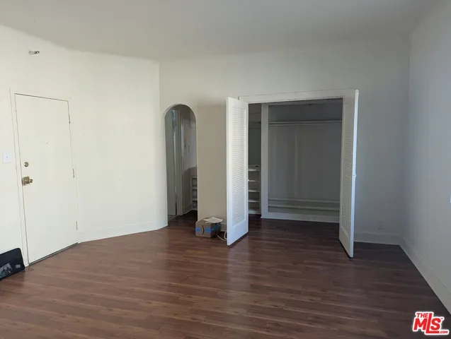 an empty room with wooden floor and closet
