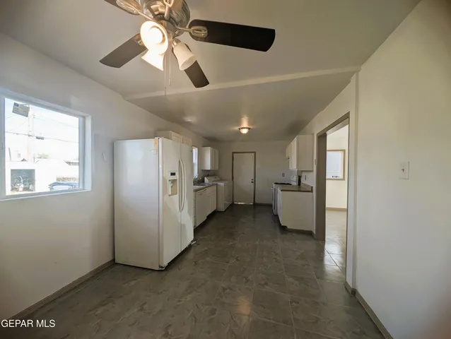 a view of a big room with chandelier fan and windows