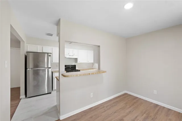 a kitchen with a refrigerator and a stove top oven
