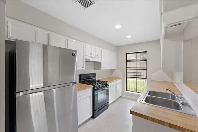 a kitchen with stainless steel appliances granite countertop a refrigerator and a sink