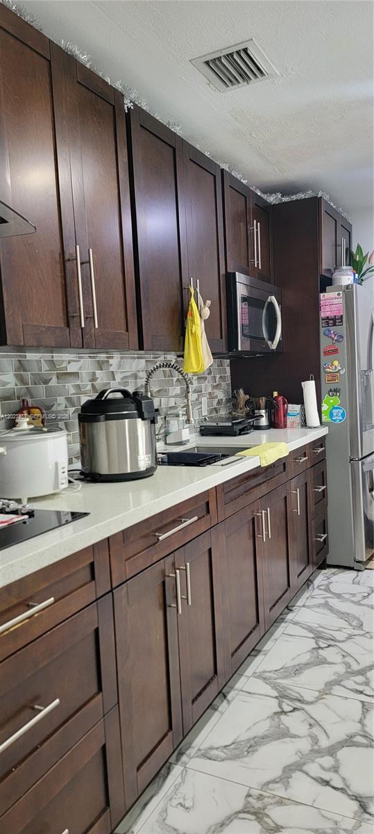 301 Southwest 36th Avenue Miami, FL 33135 - Photo 10 of 32 a kitchen with stainless steel appliances granite countertop a sink and wooden cabinets