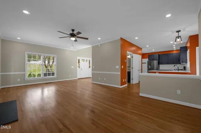 wooden floor in an empty room with a kitchen