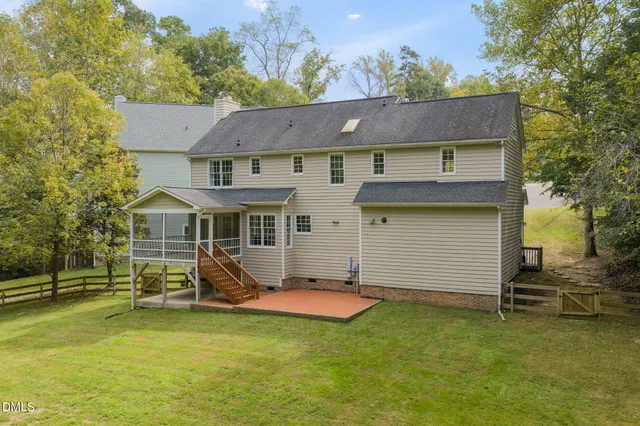 a front view of a house with a yard and trees