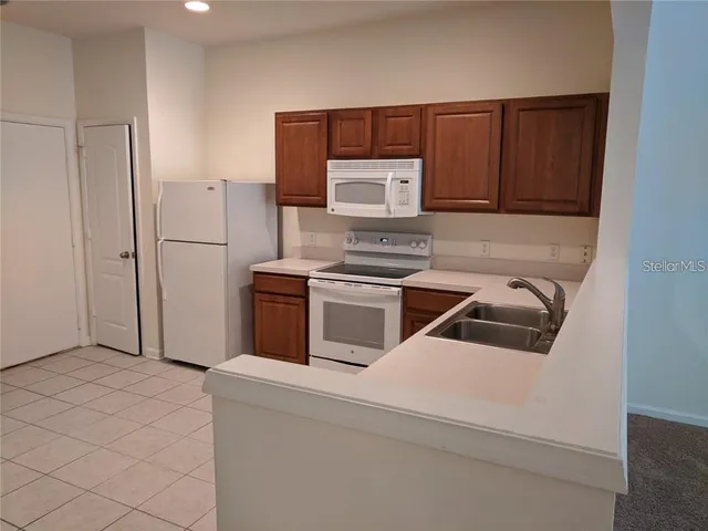 a kitchen with a refrigerator sink and cabinets