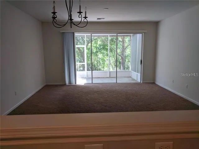 a view of empty room with window and ceiling fan