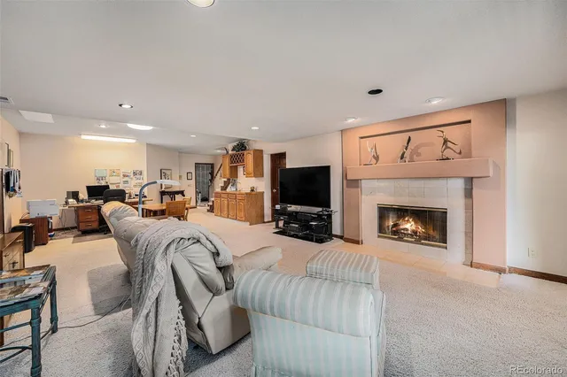 a living room with furniture a flat screen tv and a fireplace