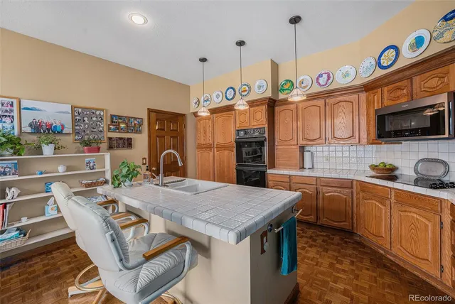 a kitchen with stainless steel appliances granite countertop a kitchen island a stove a table and chairs