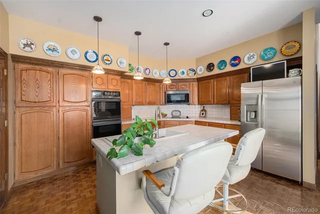 a kitchen with granite countertop a refrigerator a sink and a stove
