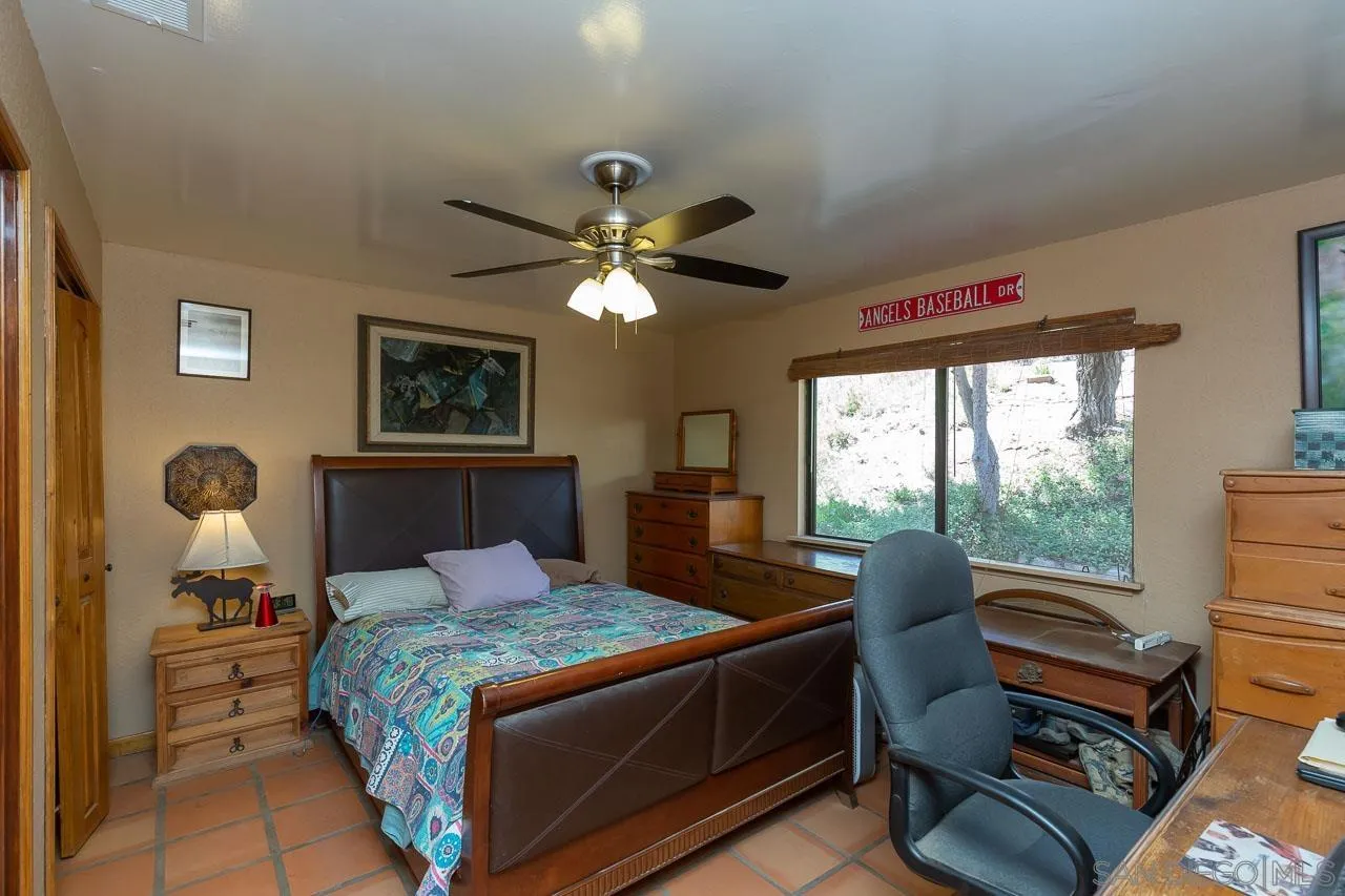 2029 Willow Glen Road Fallbrook, CA 92028 - Photo 15 of 46 a bedroom with a bed and a chandelier