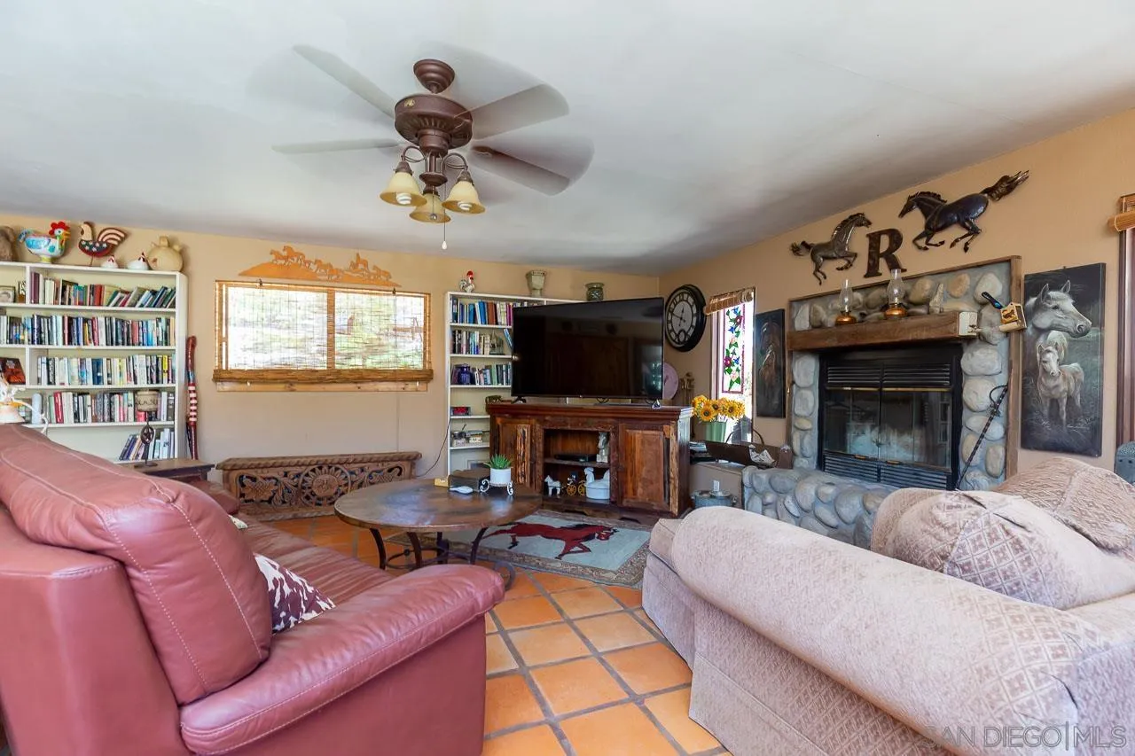 2029 Willow Glen Road Fallbrook, CA 92028 - Photo 5 of 46 a living room with furniture a flat screen tv and a fireplace
