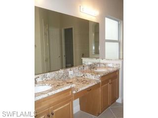 5738 Mango Circle, Unit 5738 Naples, FL 34110 - Photo 7 of 8 a bathroom with a sink and a mirror