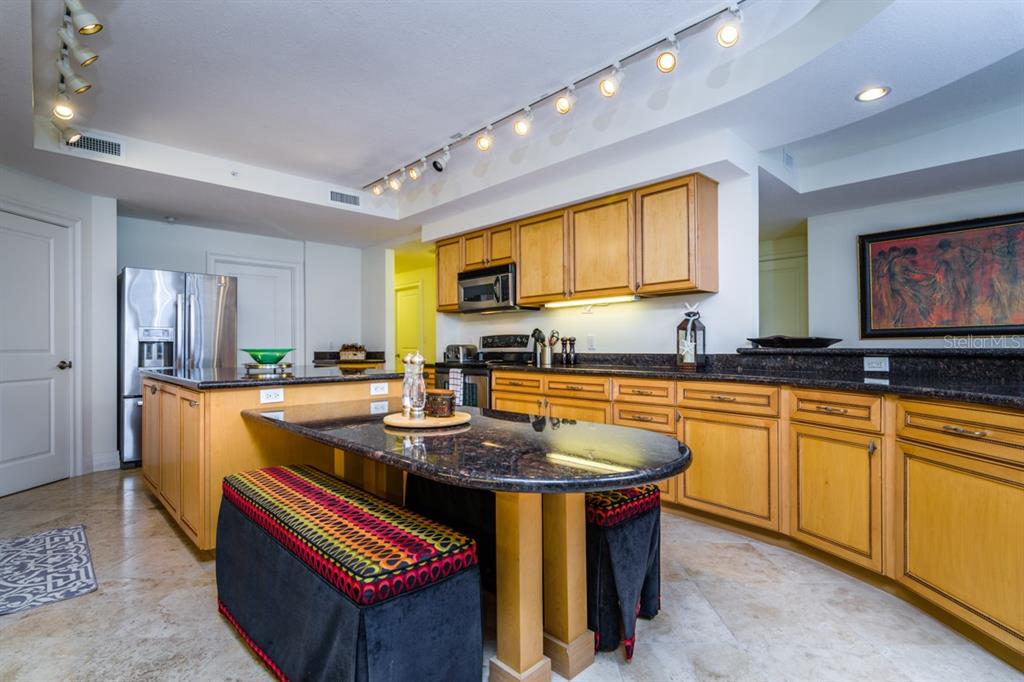 1350 Gulf Boulevard, Unit 901 Clearwater Beach, FL 33767 - Photo 19 of 63 a kitchen with stainless steel appliances granite countertop a sink a stove and a refrigerator
