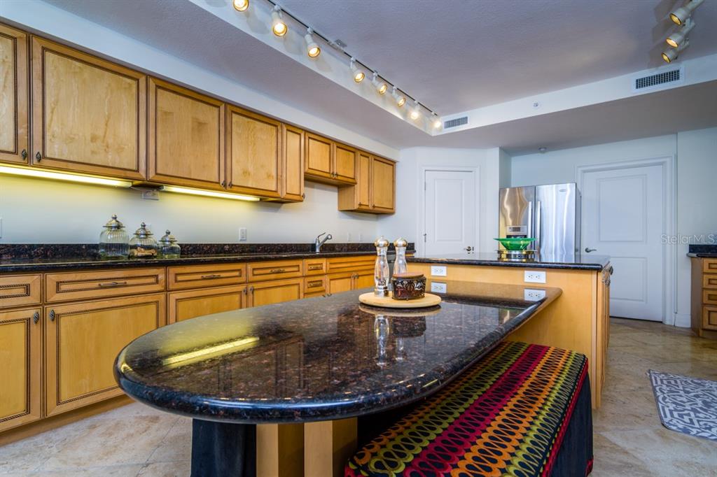 1350 Gulf Boulevard, Unit 901 Clearwater Beach, FL 33767 - Photo 23 of 63 a kitchen with stainless steel appliances granite countertop a sink dishwasher and cabinets with wooden floor