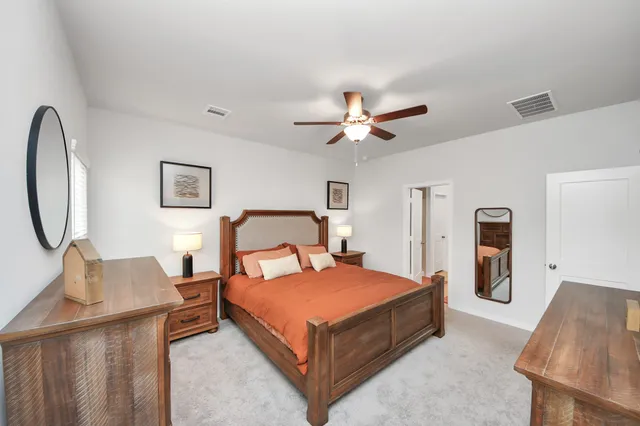 a bedroom with a bed chandelier and a window