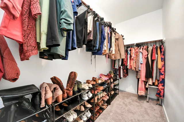 a view of walk in closet with clothes and shoes