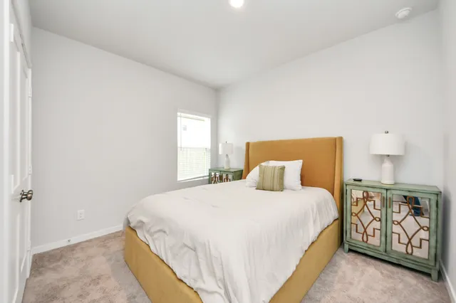 a bedroom with a bed a mirror and window