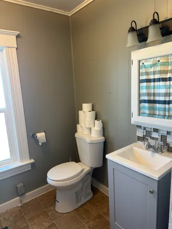a bathroom with a sink toilet and window