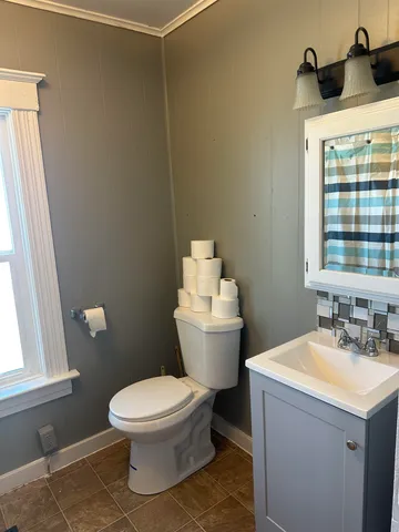 a bathroom with a sink toilet and window