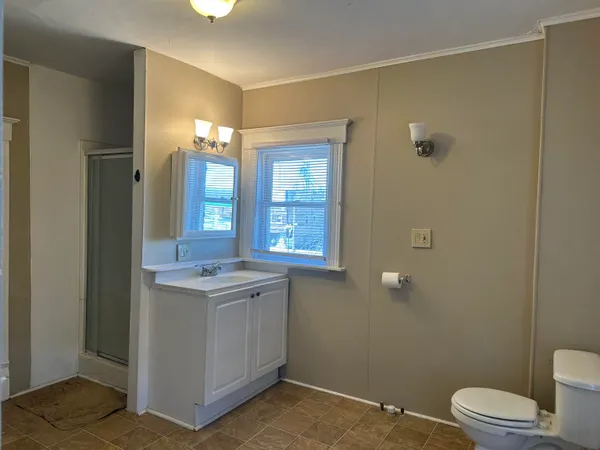 a bathroom with a granite countertop sink a toilet and a mirror