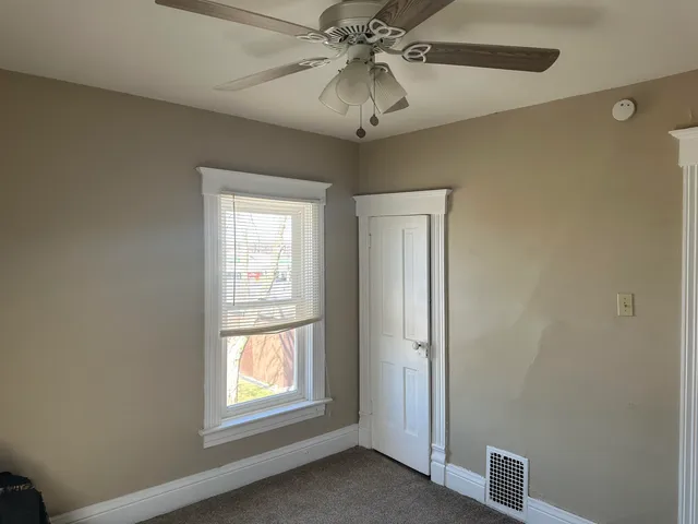 a view of a livingroom with a window and a chandelier fan