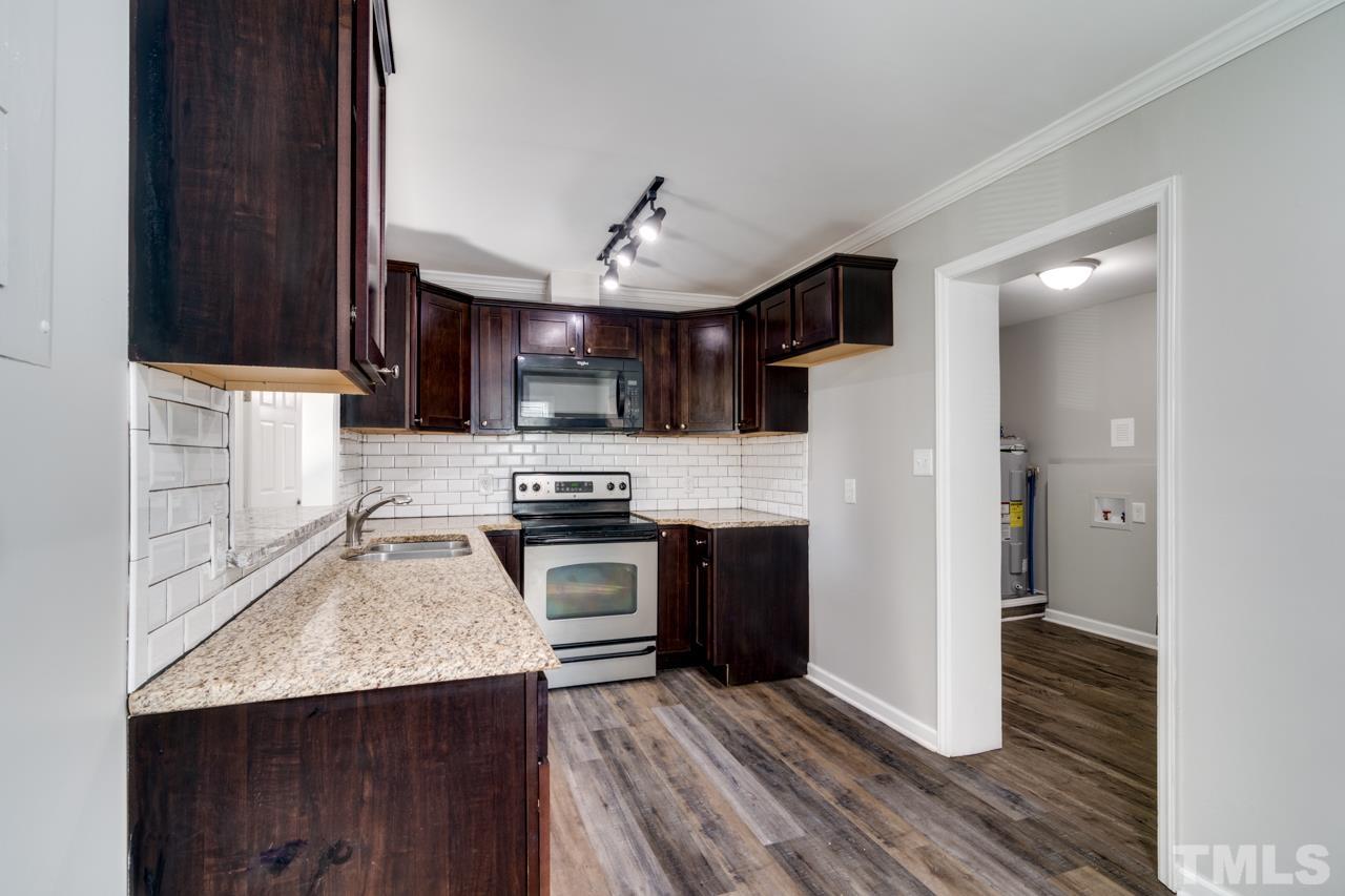 213 Angier Avenue Raleigh, NC 27610 - Photo 14 of 38 a kitchen with granite countertop a stove a sink and a refrigerator