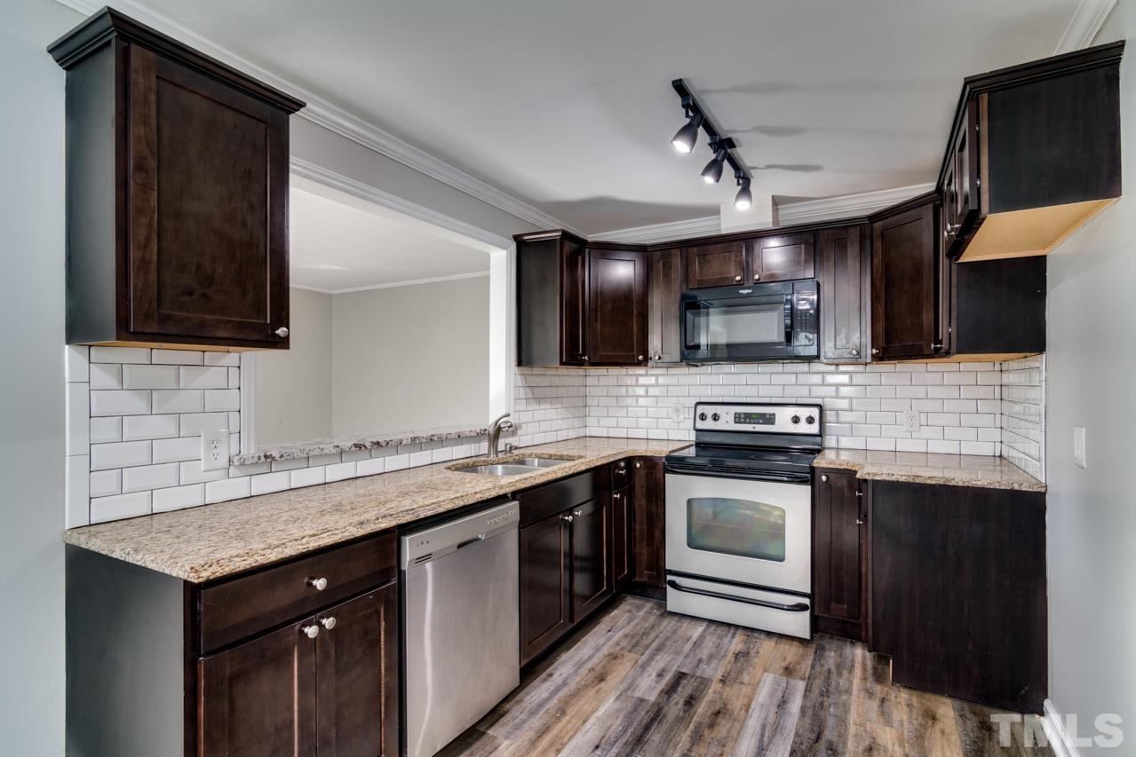 213 Angier Avenue Raleigh, NC 27610 - Photo 15 of 38 a kitchen with stainless steel appliances granite countertop a sink stove and microwave