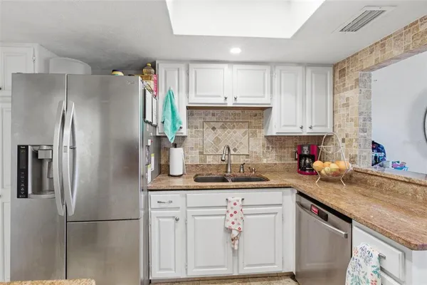 a kitchen with stainless steel appliances granite countertop a refrigerator sink and cabinets