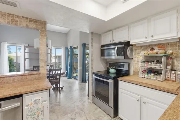 a kitchen with stainless steel appliances granite countertop a stove a sink and a microwave